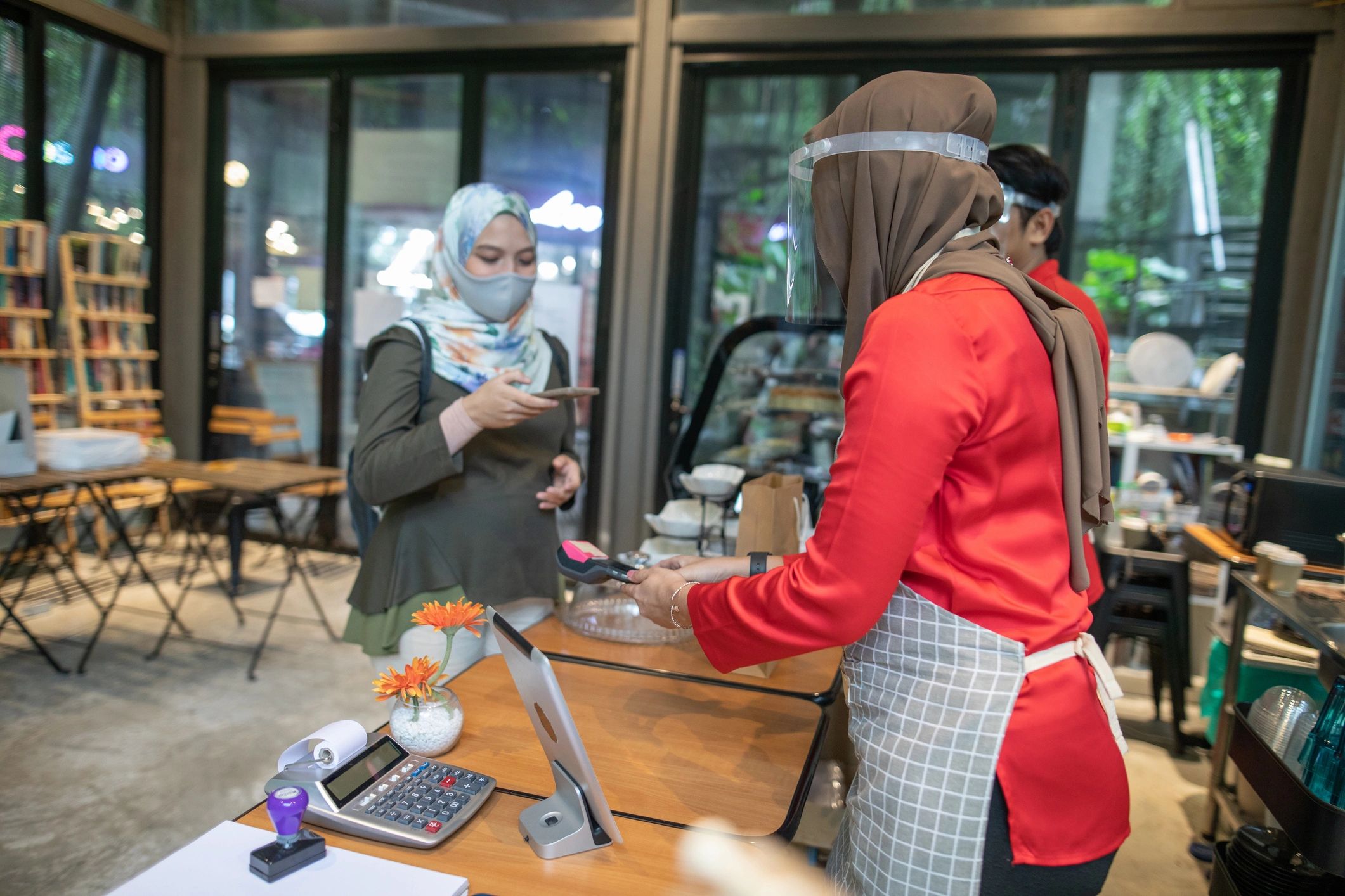 Guests making a contactless payment at a counter