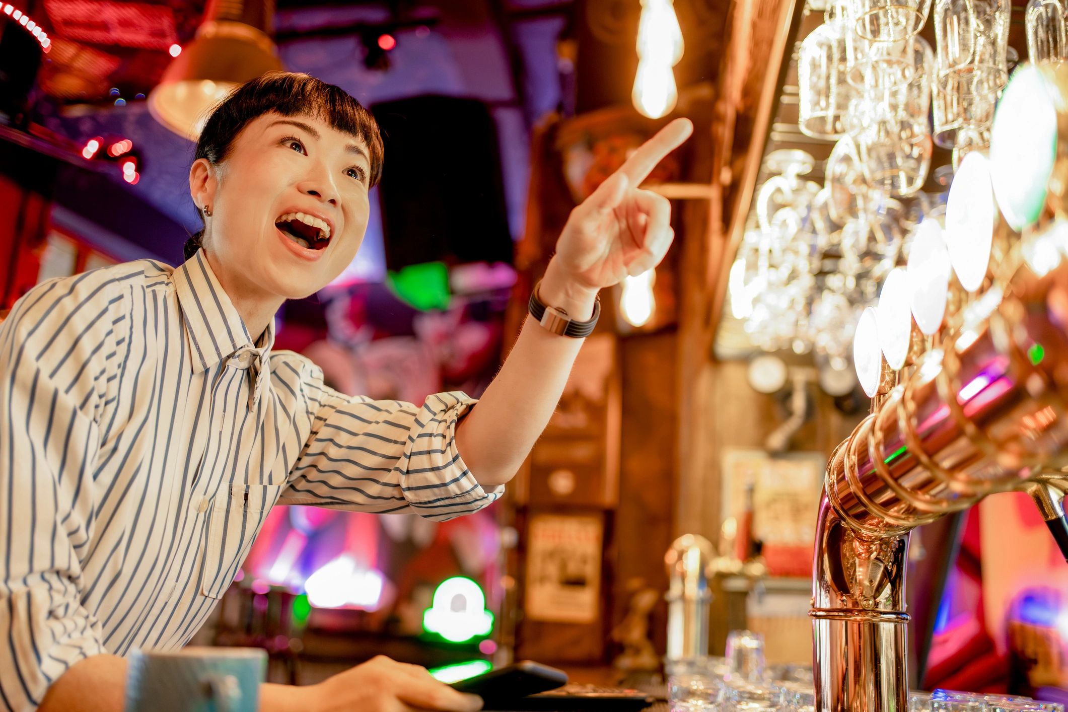 Bartender serving guests in a lively bar